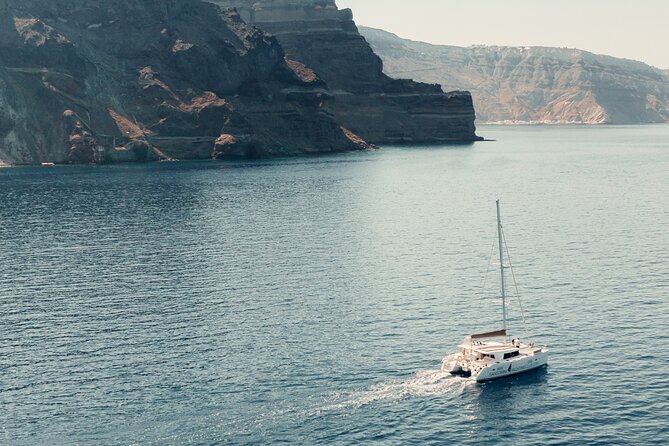 Beautiful Day Catamaran Caldera Cruise incl. Meal & Drinks - Indian Rock, the lighthouse, and Santorini’s volcanic coast