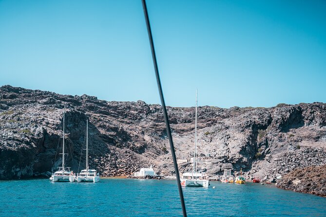 Majestic Catamaran Caldera Cruise with Snacks, Meal & Drinks - Passing Red Beach and the caldera cliffs