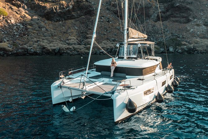Majestic Catamaran Caldera Cruise with Snacks, Meal & Drinks - Leaving Ammoudi Bay beneath Oia