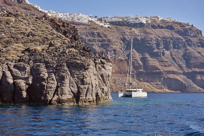 Santorini: Caldera Private Catamaran Cruise with Meal & Drinks - Red Beach, where Santorini turns scarlet