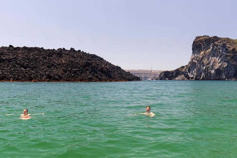 Santorini: Catamaran Cruise with Fresh Meal & Open Bar - Passing beneath Akrotiri Lighthouse