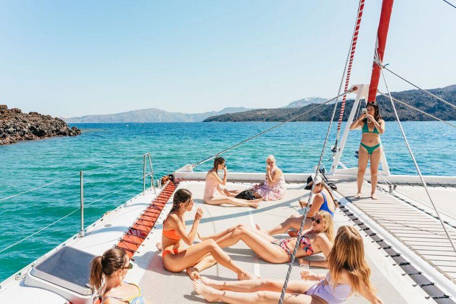 Santorini: Catamaran Tour with BBQ Dinner, Drinks, and Music - White Beach beneath the bright cliffs