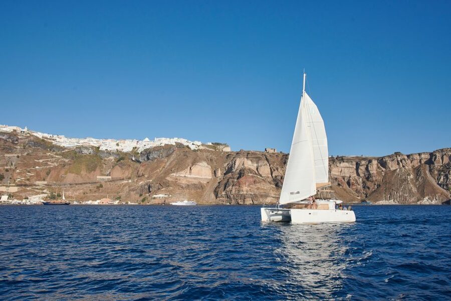 Santorini Gold Catamaran Cruise with Snorkel, BBQ & Open Bar - White Beach, the lighthouse, and volcanic rock