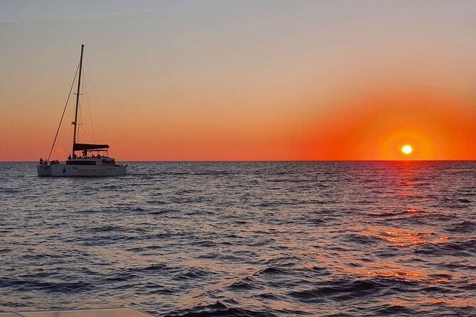 Santorini Private Catamaran Cruise with BBQ, Open Bar & Transfers - Indian Rocks, the lighthouse, and the caldera from below