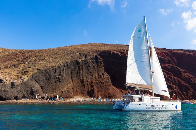 Santorini Private Catamaran Cruise with BBQ, Open Bar & Transfers - Red Beach and the first view of Santorini’s geology