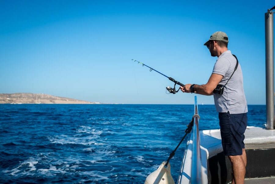Santorini Sunset Fishing Trip with Dinner and Drinks - Fishing with rods, lines, and live bait